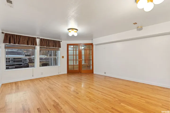 Spare room featuring french doors and light wood-style floors