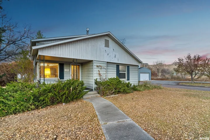 Bungalow-style house featuring an outdoor structure, a detached garage, and covered porch