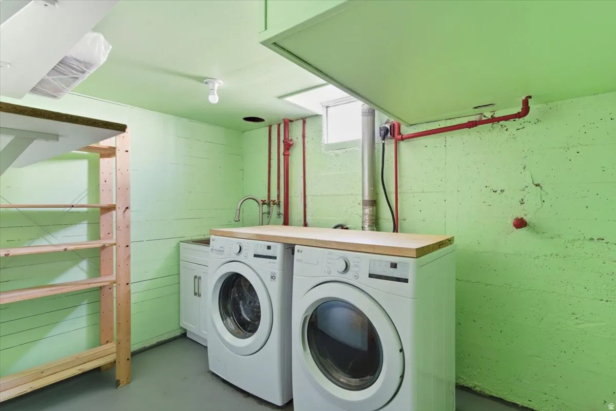 Dedicated laundry area featuring a utility sink, light wood-finish countertop, and full-size appliances