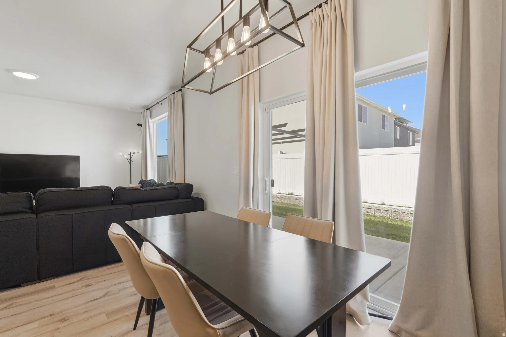 Dining area featuring a contemporary linear chandelier and light wood-finish flooring