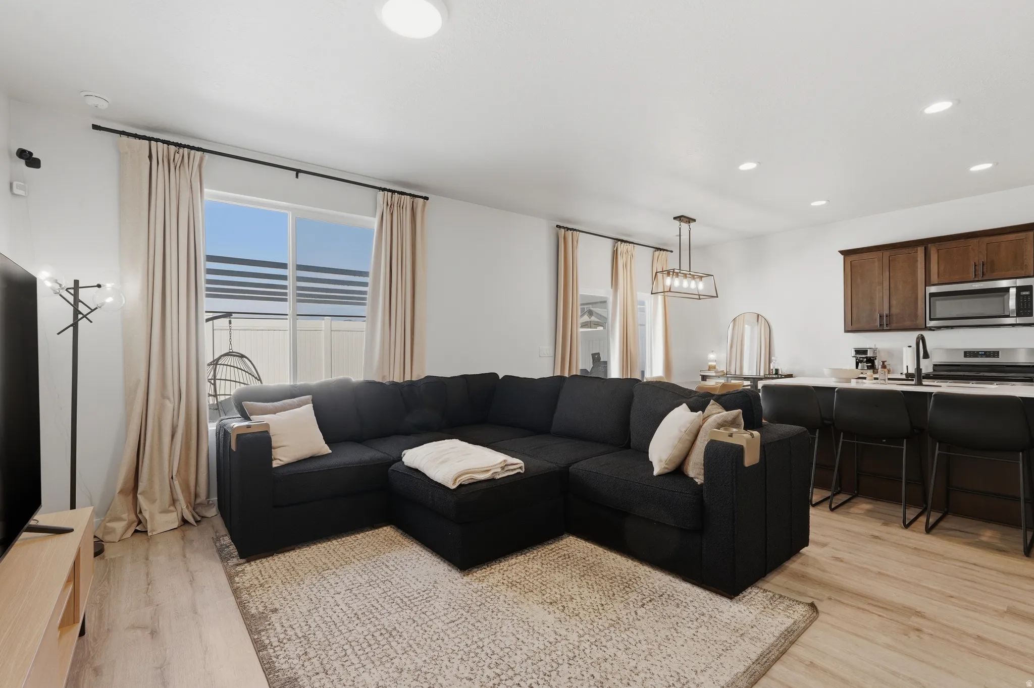 Open-concept common area featuring wood-finish flooring, recessed lighting, and a window with horizontal blinds