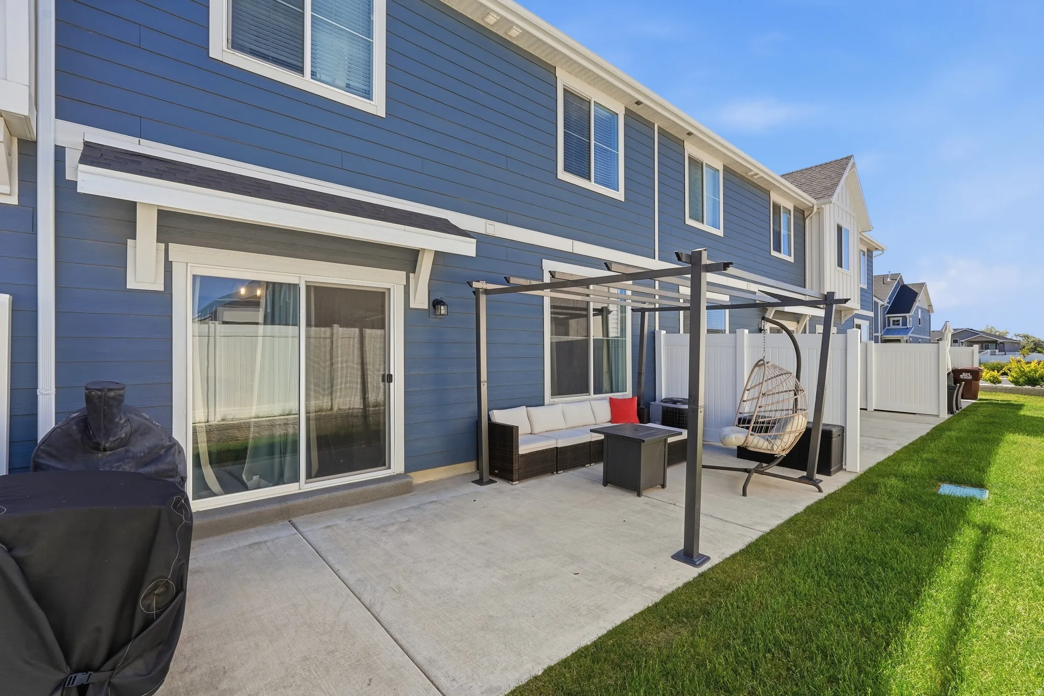 Expansive concrete patio with a modern pergola framework