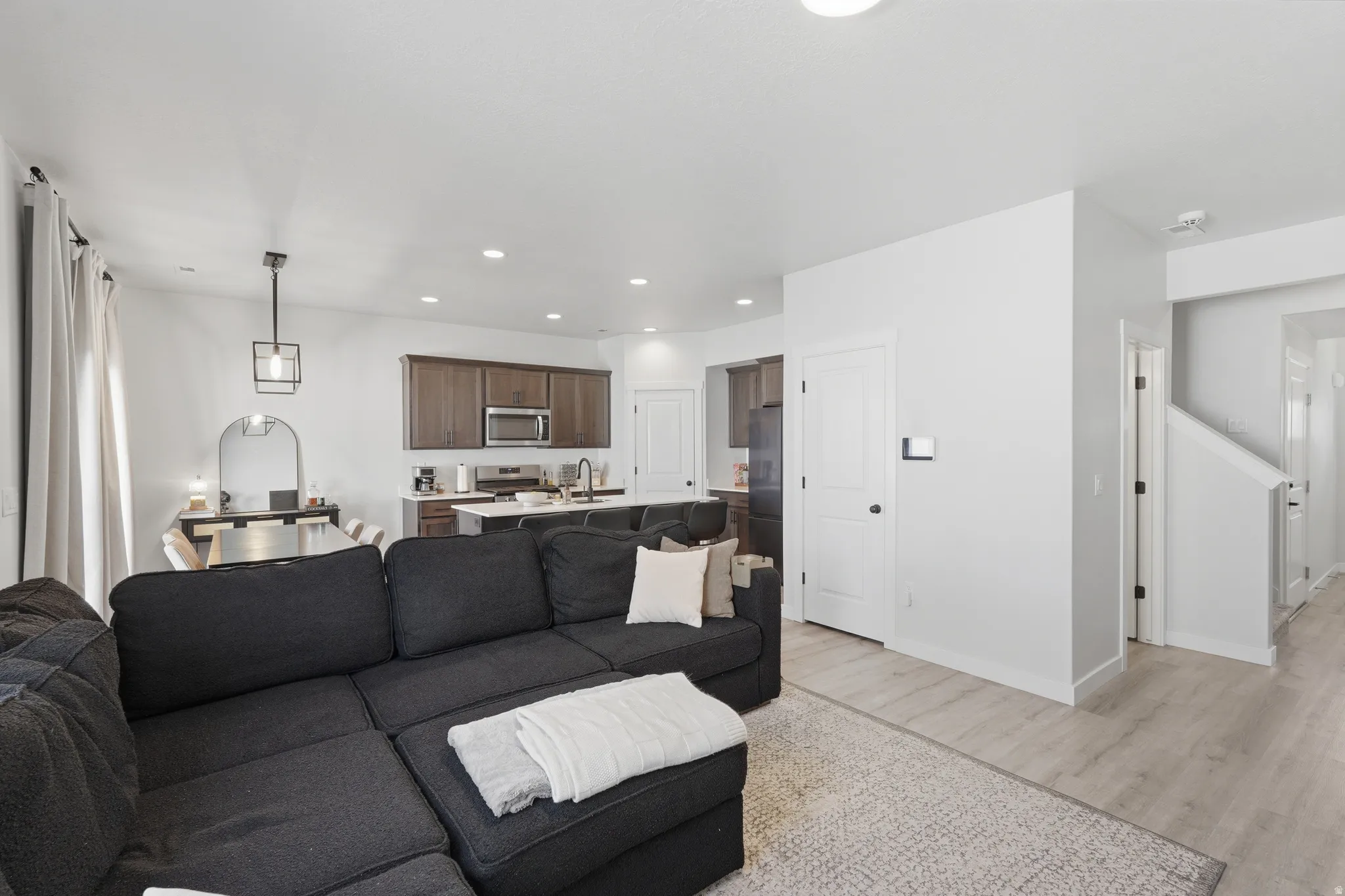 Open-concept living area featuring light wood-finish flooring and recessed lighting