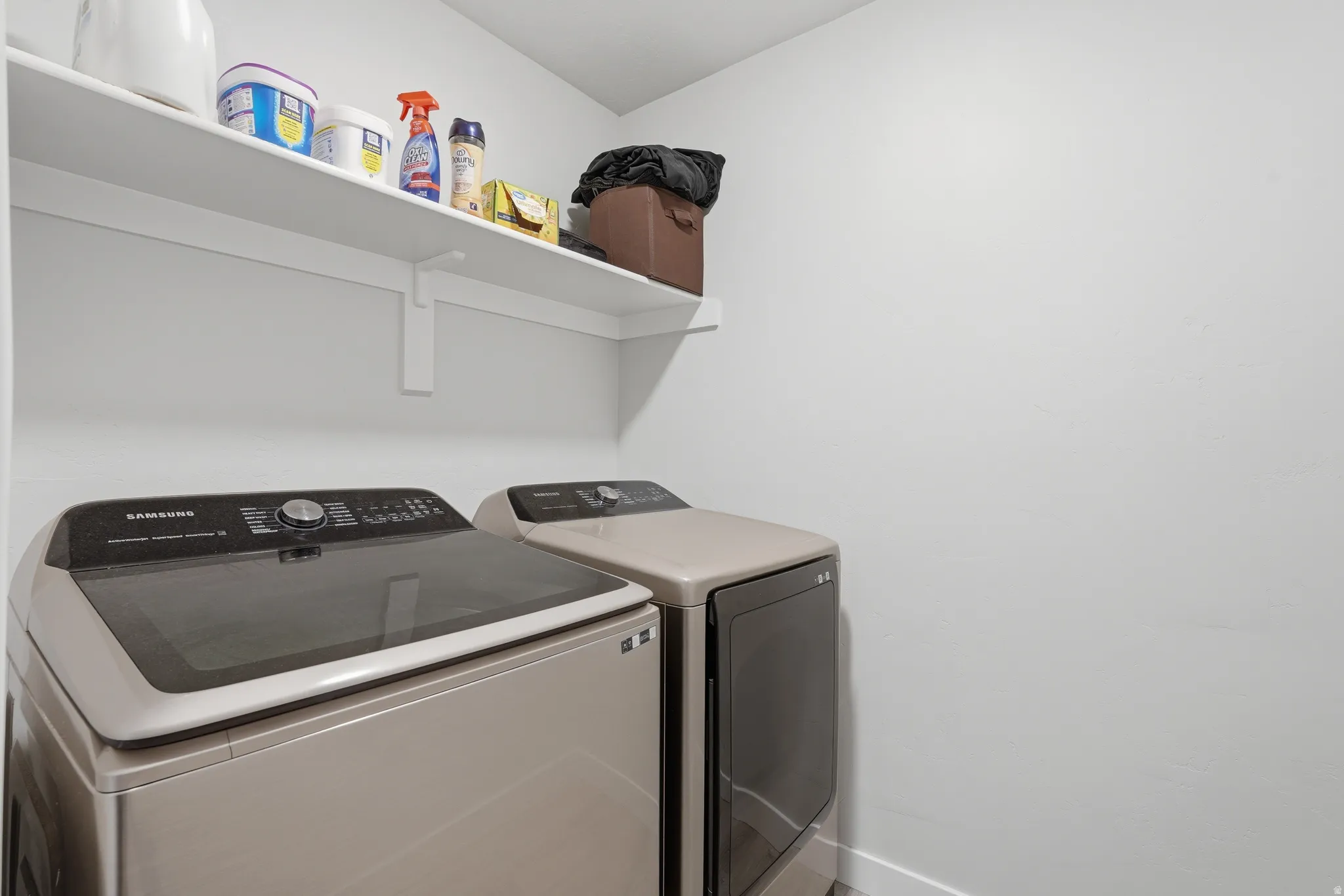 Dedicated laundry area featuring a wall-mounted white shelf