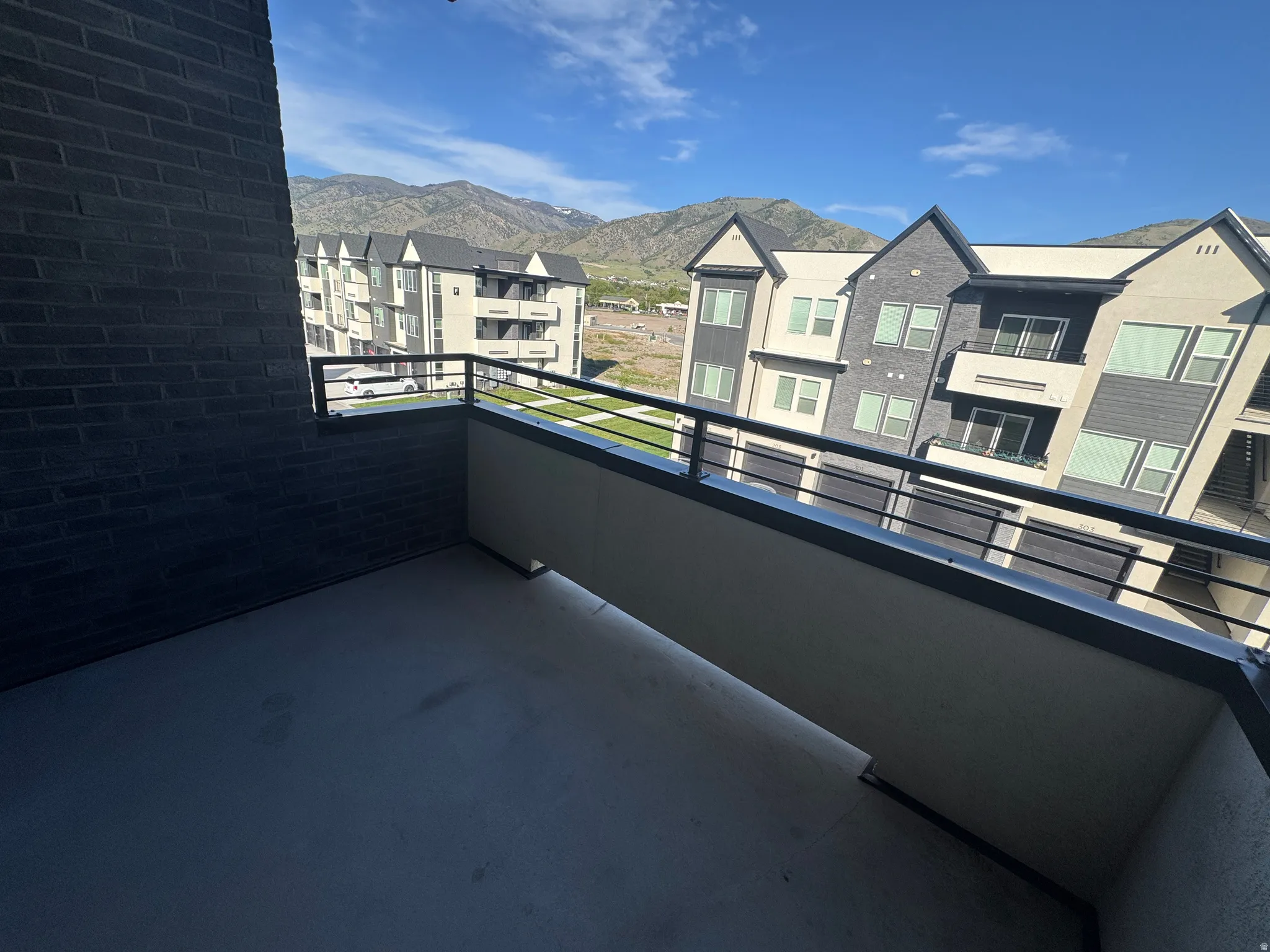 Private balcony featuring a concrete surface and black metal railings