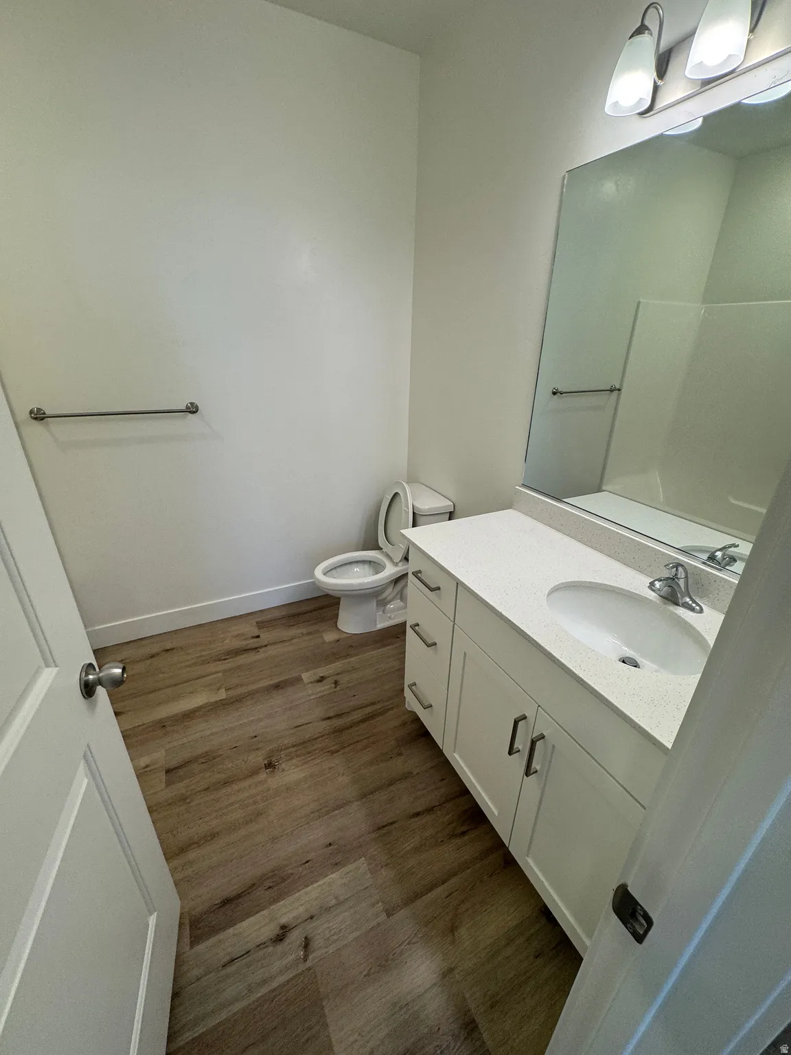 Bathroom featuring a white vanity with an integrated sink, polished chrome faucet, and a large mirror