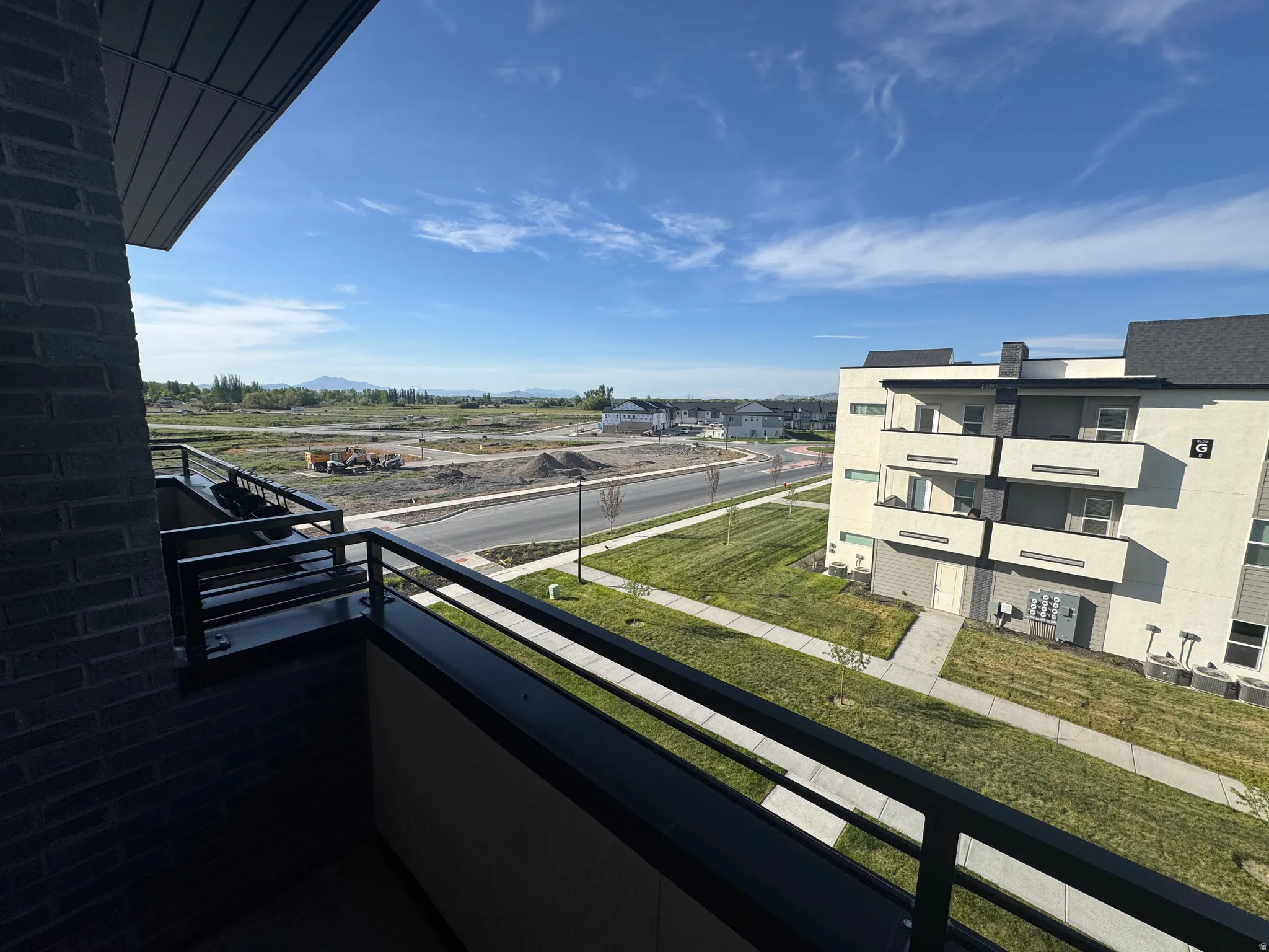 Private balcony with black metal railings, offering an expansive outdoor outlook