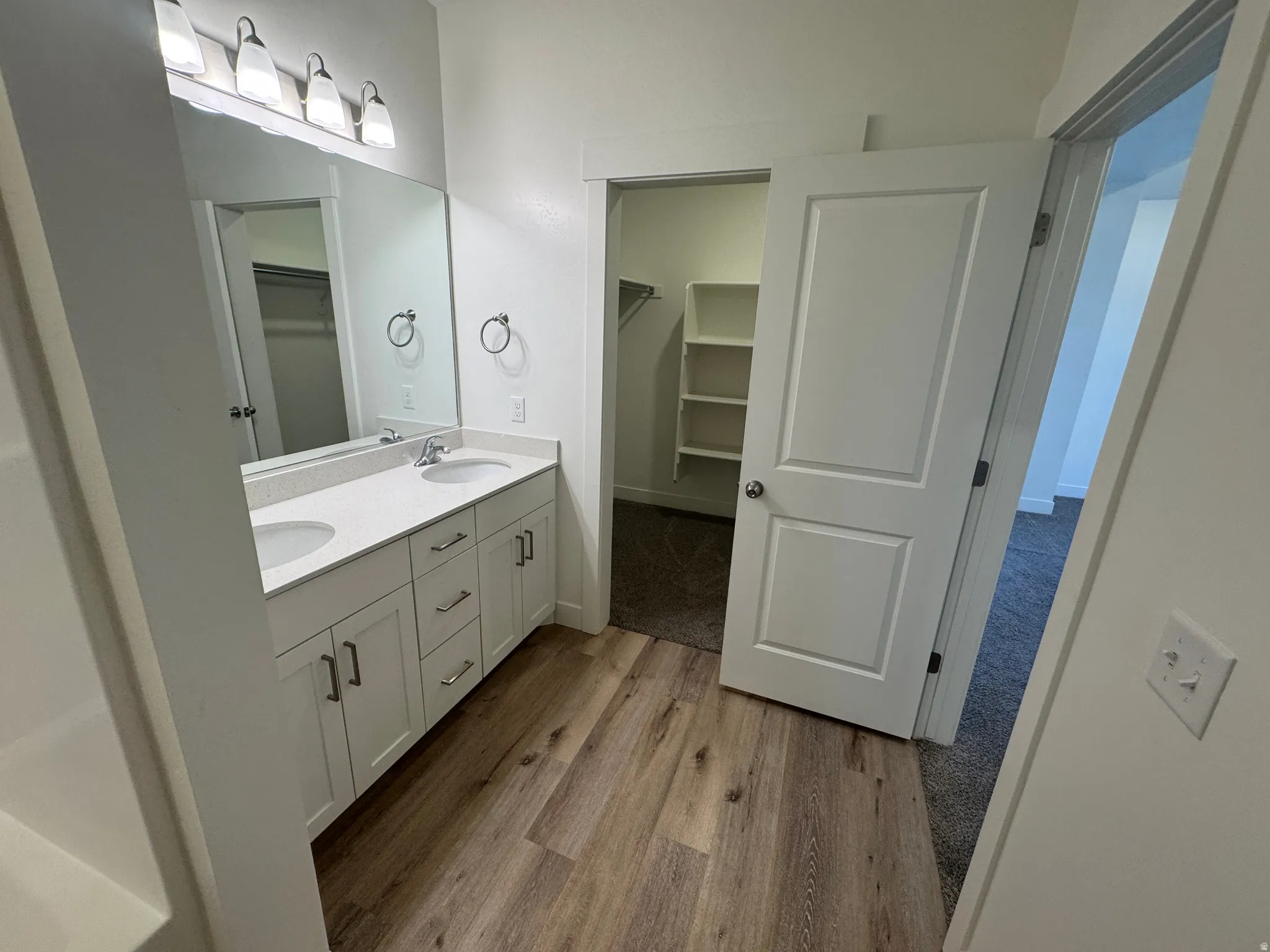 Bathroom featuring a double vanity with stone-finish countertops and integrated sinks