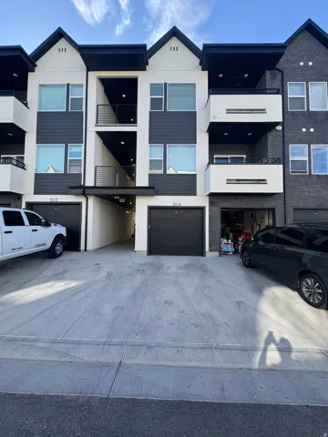Modern multi-story townhome exterior featuring contemporary black and white color scheme