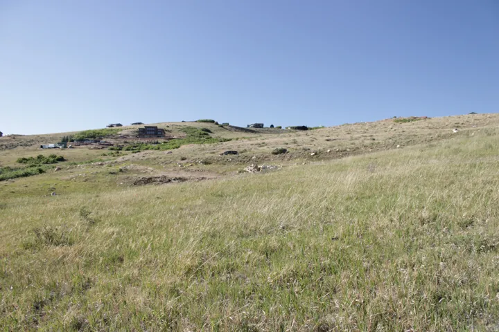 Expansive rolling hills with natural grass and scattered rock formations