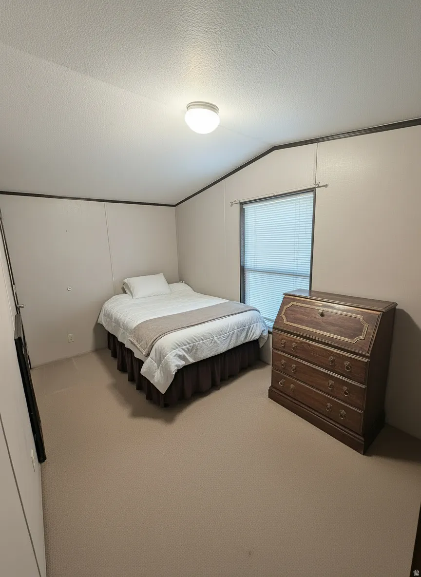 Carpeted room featuring a single window with blinds, a flush-mount ceiling light fixture, and neutral-toned walls with dark trim