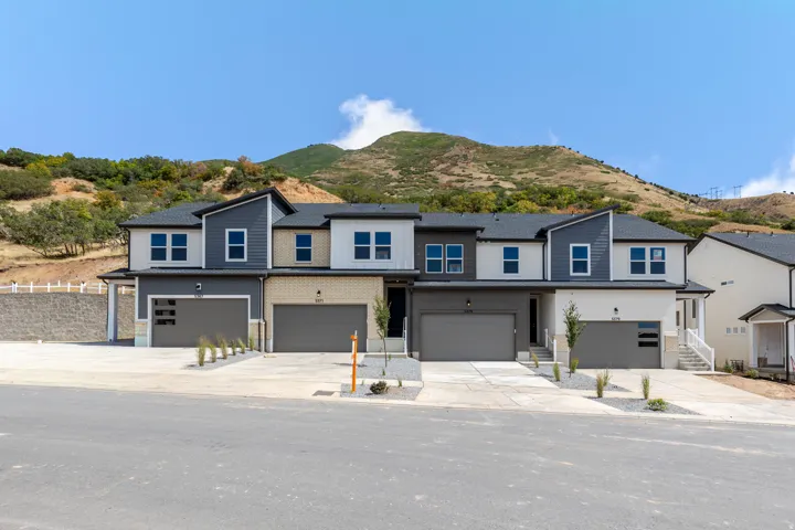 Modern multi-level exterior with integrated garage doors and varied siding textures