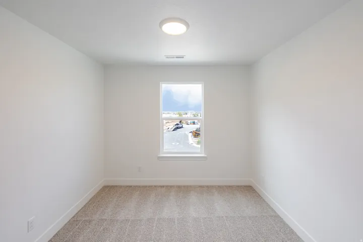 Neutral wall tones with carpet flooring and a single window