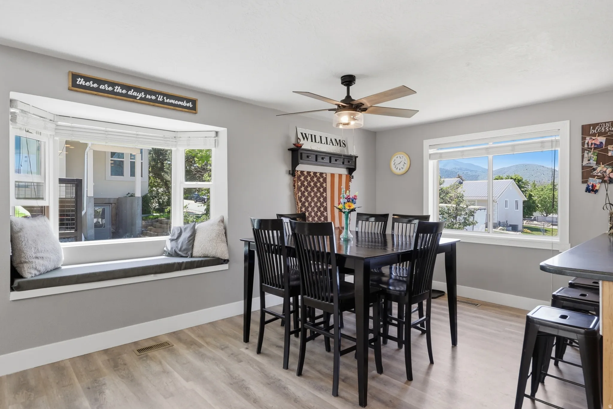 Dining area featuring light wood-finish flooring and a contemporary ceiling fan