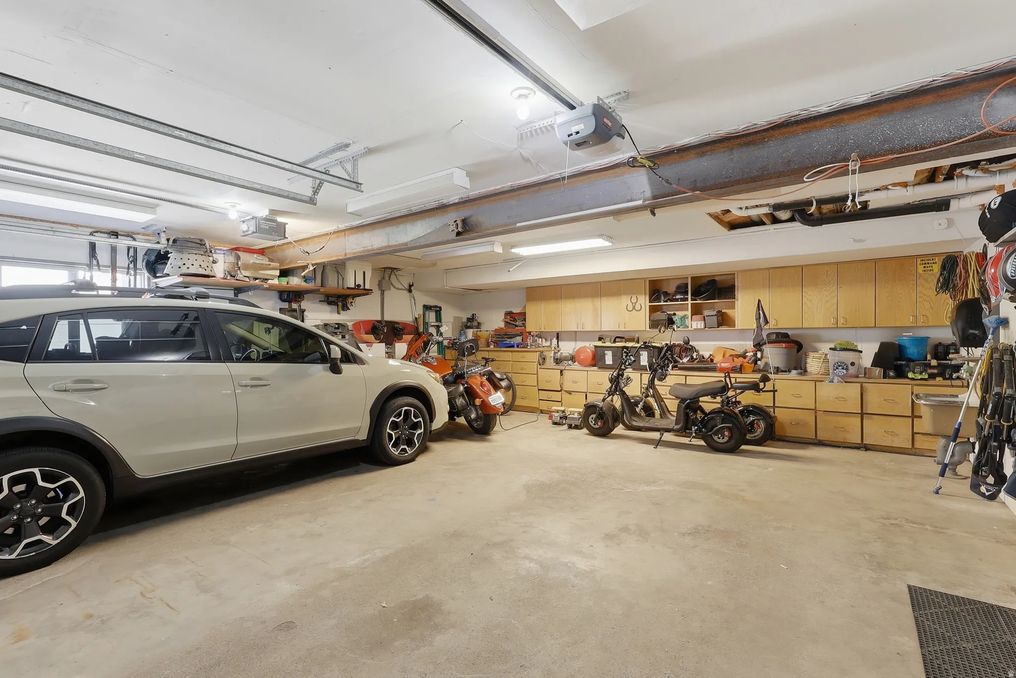 Spacious garage with exposed structural beams and concrete flooring