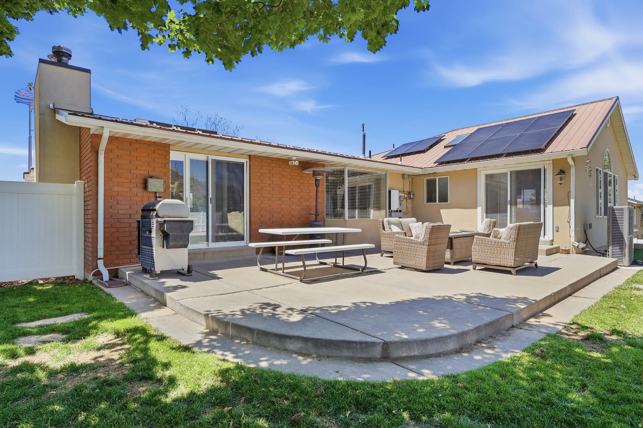 Expansive concrete patio with curved edges and a stucco and brick exterior