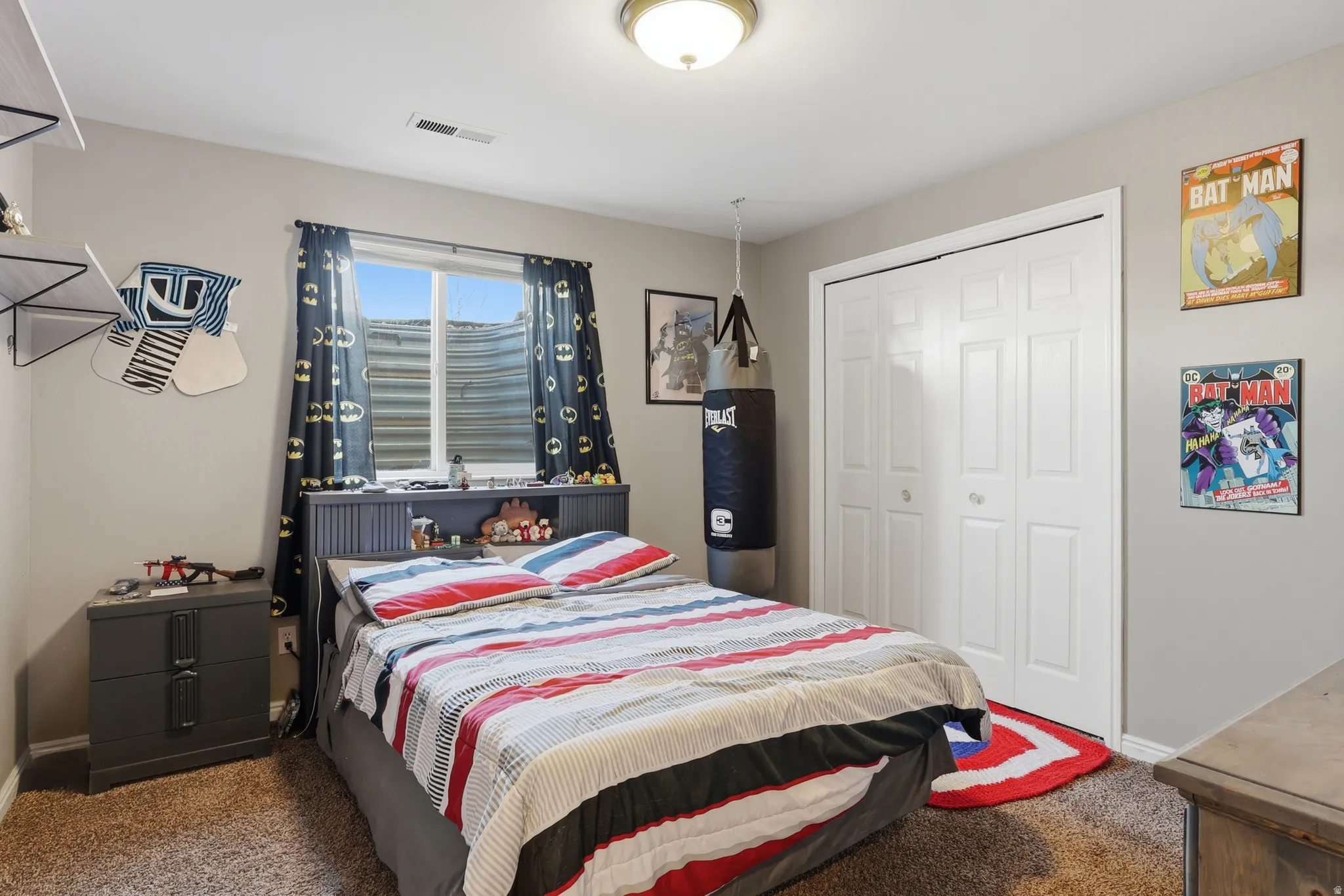 Bedroom featuring a window with privacy screening, neutral wall paint, and textured carpeting