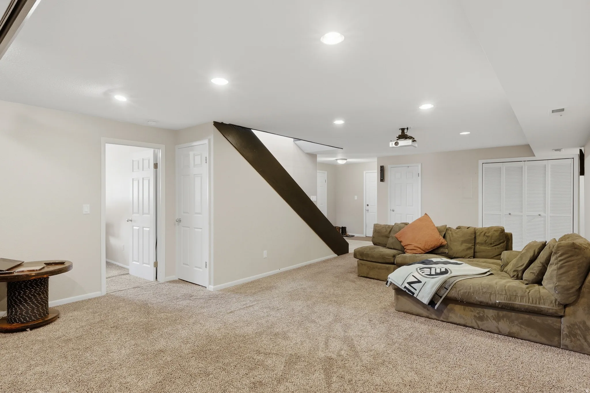 Spacious room featuring neutral carpet flooring, recessed lighting, and light-toned walls