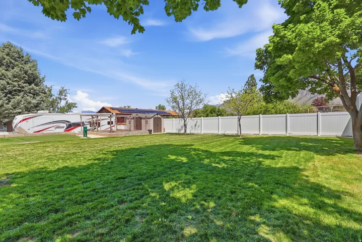 Expansive green lawn with a white privacy fence