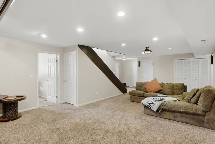 Spacious room featuring neutral carpet flooring, recessed lighting, and light-toned walls