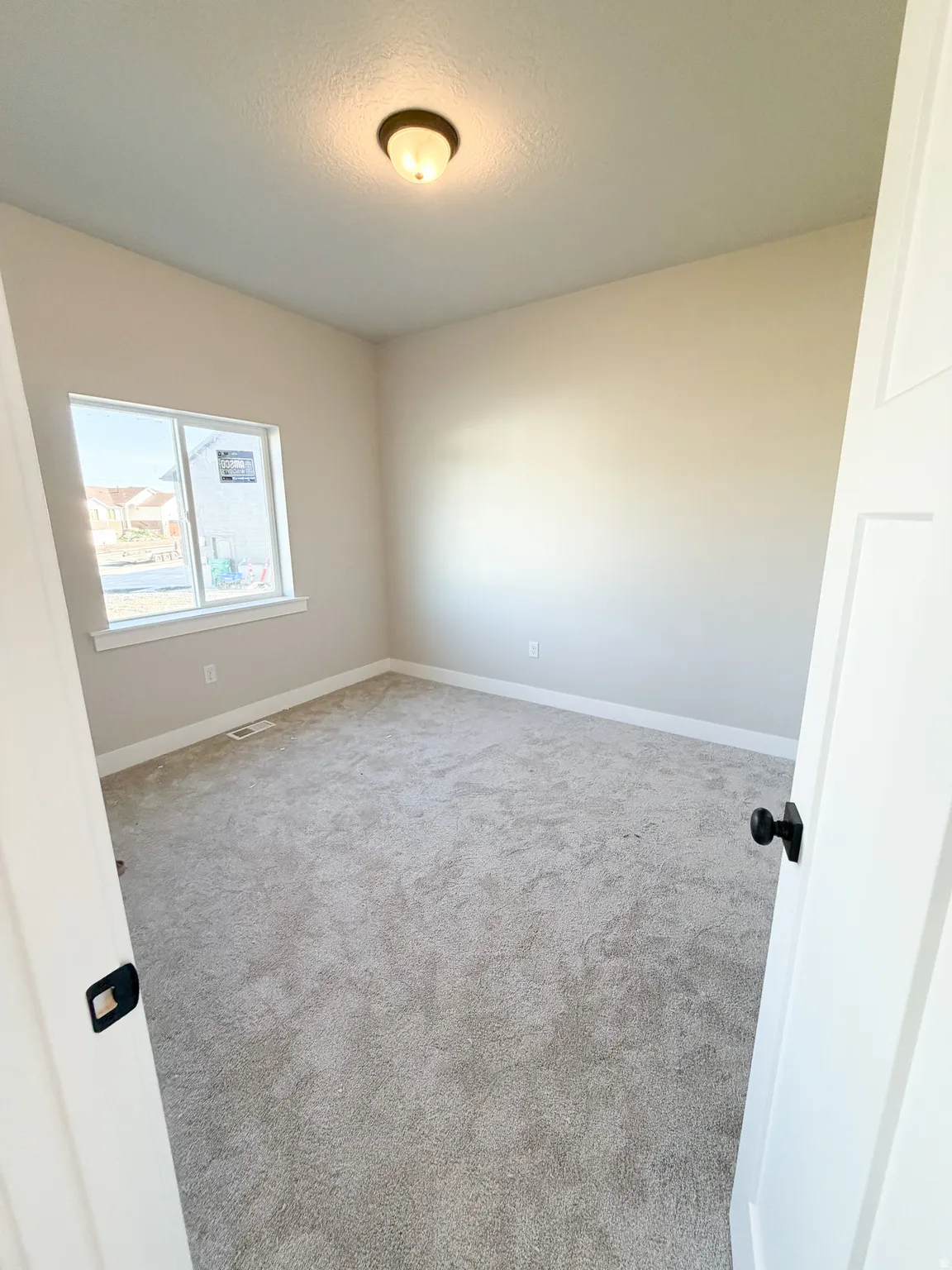 Spacious room featuring neutral carpeting and light-toned walls