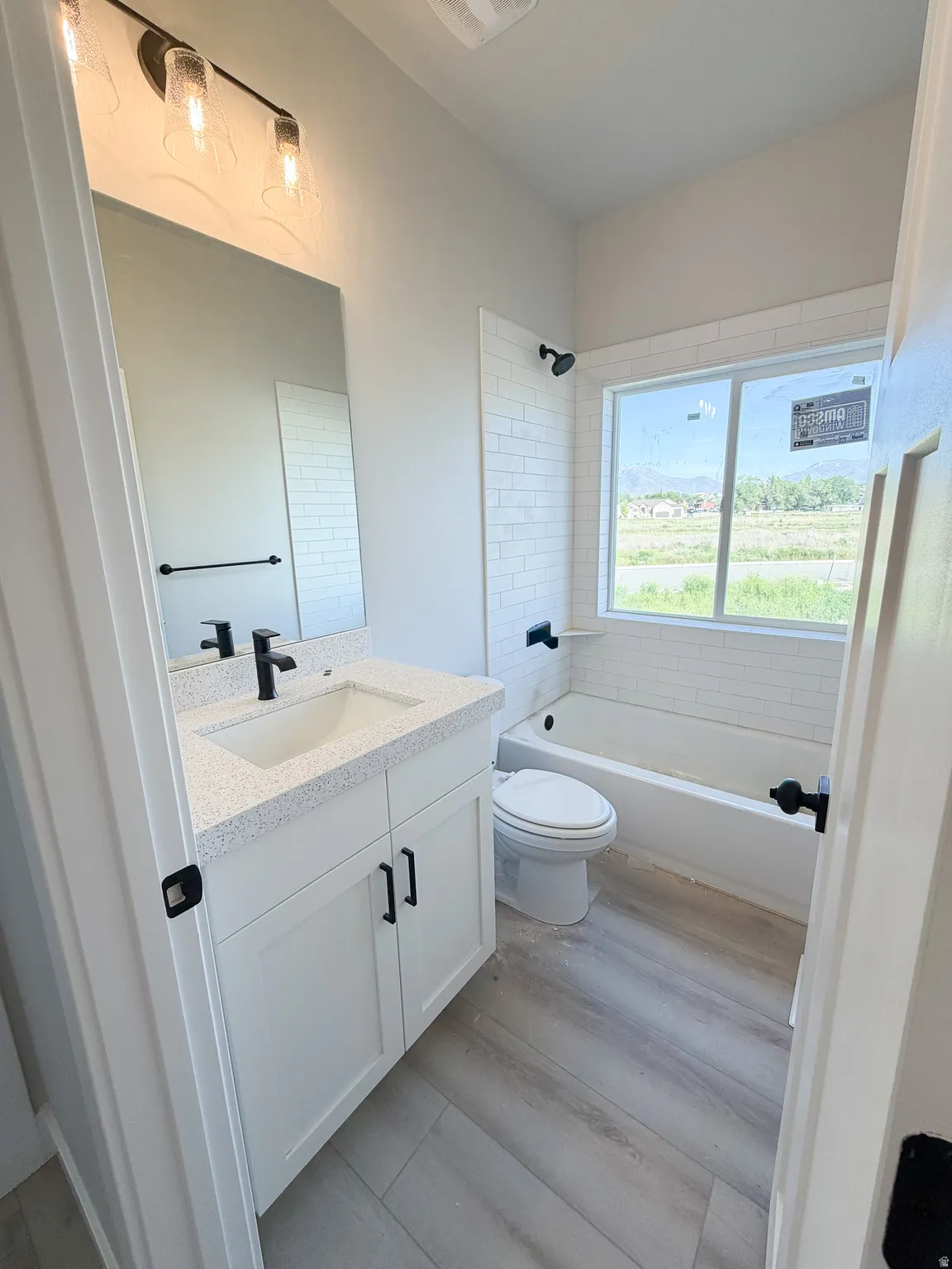 Bathroom featuring a white vanity with a light-toned countertop, rectangular sink, and matte black faucet