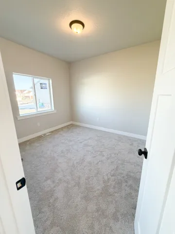 Spacious room featuring neutral carpeting and light-toned walls