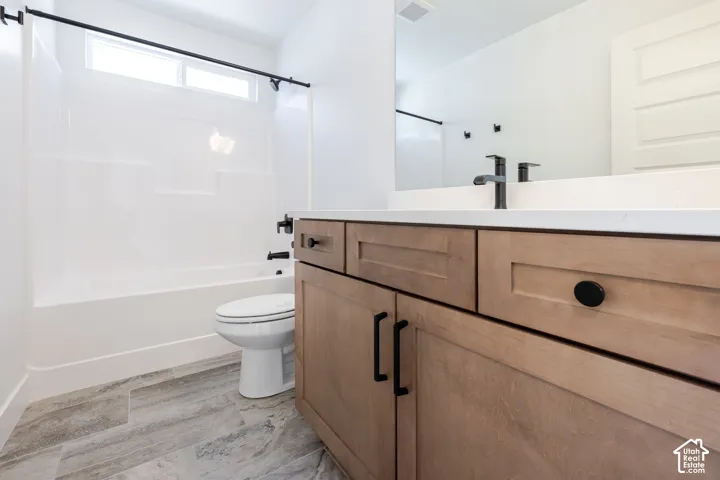 Wood-finish vanity with matte black hardware, white countertop, integrated sink, and matte black faucet