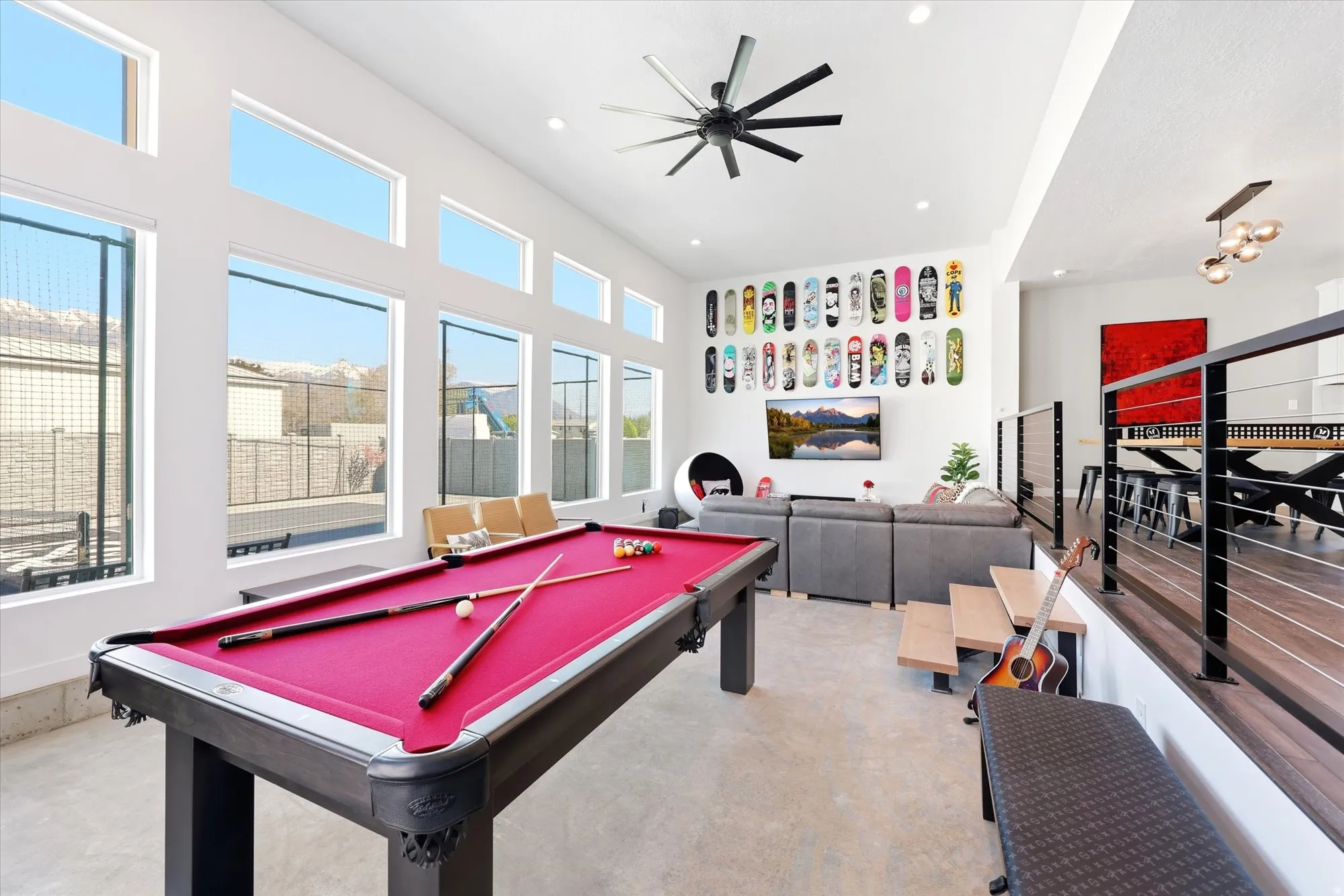 Entertainment space featuring a pool table with crimson felt, a vaulted ceiling, and an industrial-style ceiling fan