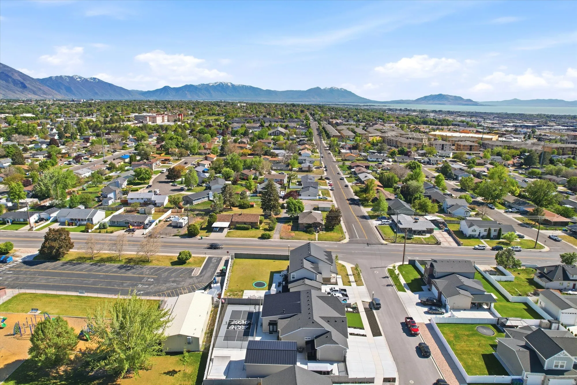 Aerial perspective showcasing a residential area with extensive tree coverage and a distant mountain range