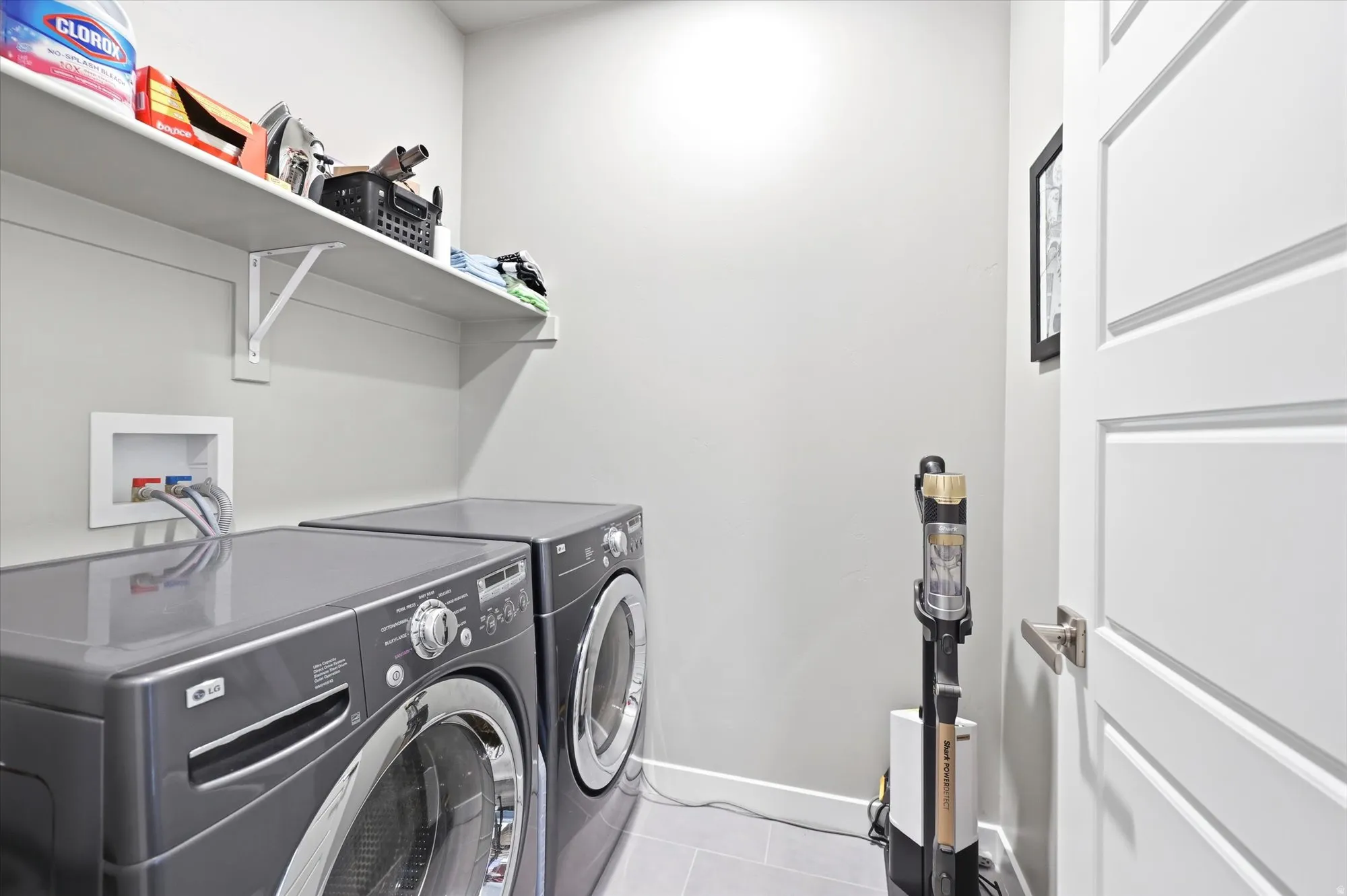 Laundry area with tile flooring and light gray walls