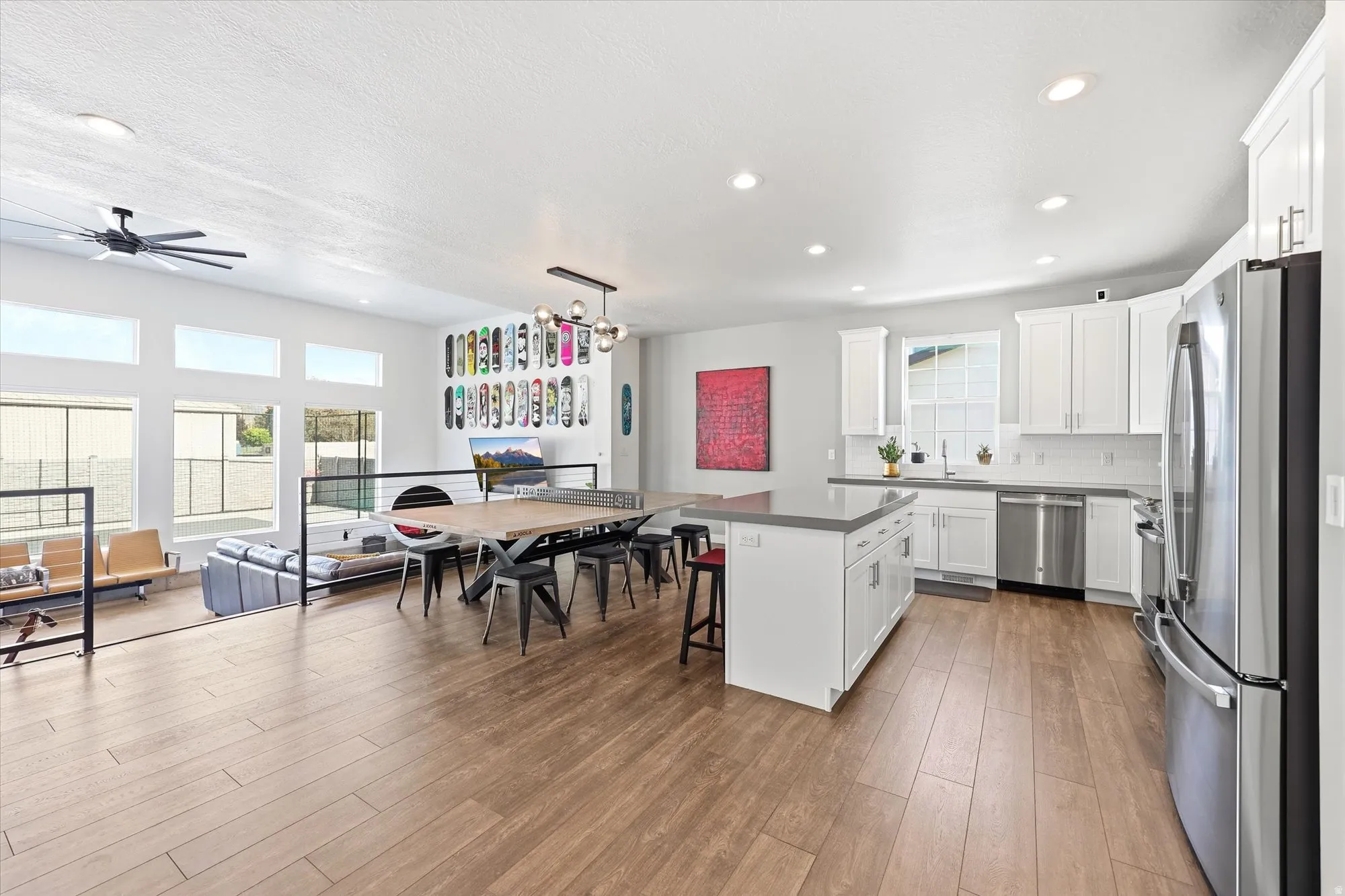 Open concept living area featuring wood-finish flooring, recessed lighting, and a contemporary kitchen