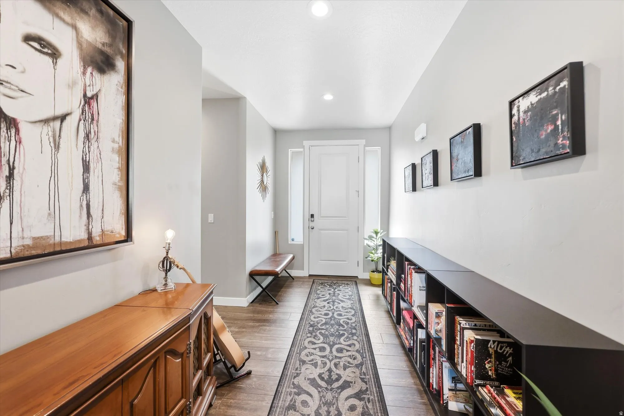 Bright entryway featuring wood-finish flooring and a decorative runner