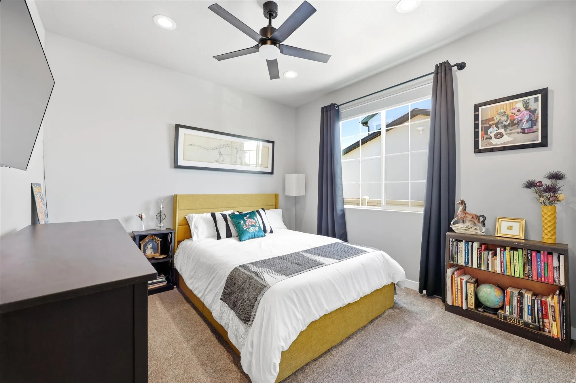 Carpeted room featuring a ceiling fan with light, recessed lighting, and a window with white grids and dark drapery