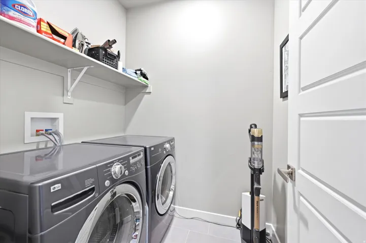 Laundry area with tile flooring and light gray walls