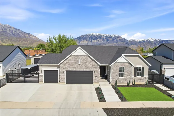 Contemporary home featuring a stone and stucco exterior, dark asphalt shingle roof, two-car garage, and a concrete driveway