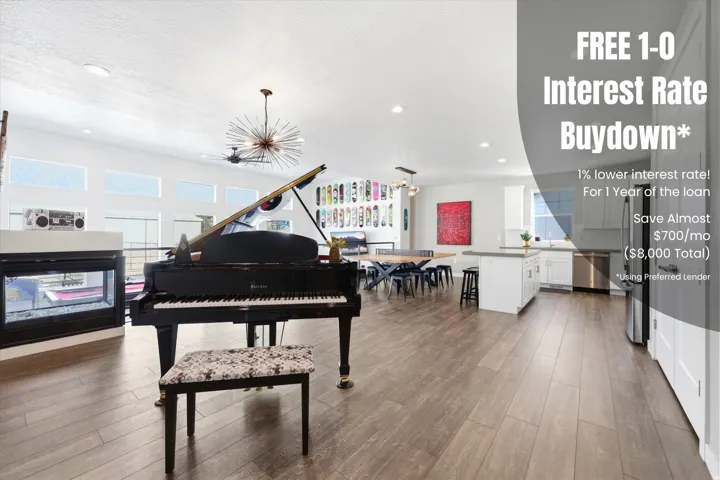 Spacious open-concept living area featuring wood-finish flooring, a linear fireplace with a white surround, and an integrated kitchen with stainless steel appliances