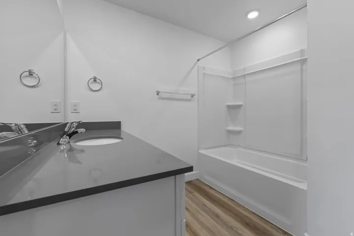 Bathroom featuring a single vanity with an undermount sink, a dark countertop, and chrome fixtures