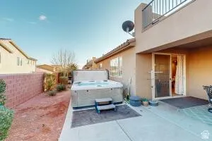 Ground-level patio with a hot tub and adjacent sliding glass door access