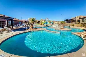 Expansive outdoor pool area featuring a multi-level swimming pool, integrated water features, and a surrounding pool deck