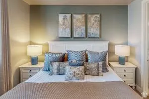 Bedroom featuring a white paneled headboard and two coordinating nightstands with drawer storage