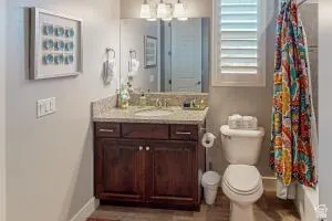 Bathroom featuring a wood-finish vanity with a light-colored countertop and undermount sink