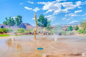 Splash pad featuring multiple water spray features, a central water play structure, and a durable surface