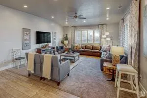 Expansive living area featuring recessed lighting, a ceiling fan, and a large window with plantation shutters