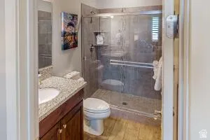 Bathroom featuring a vanity with a light-colored speckled countertop, an undermount sink, and dark wood cabinetry