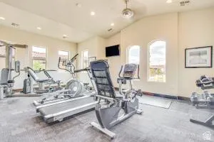 Spacious fitness room featuring vaulted ceilings, arched windows, and recessed lighting