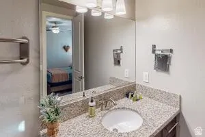 Bathroom vanity featuring a granite countertop, undermount sink, and brushed nickel faucet