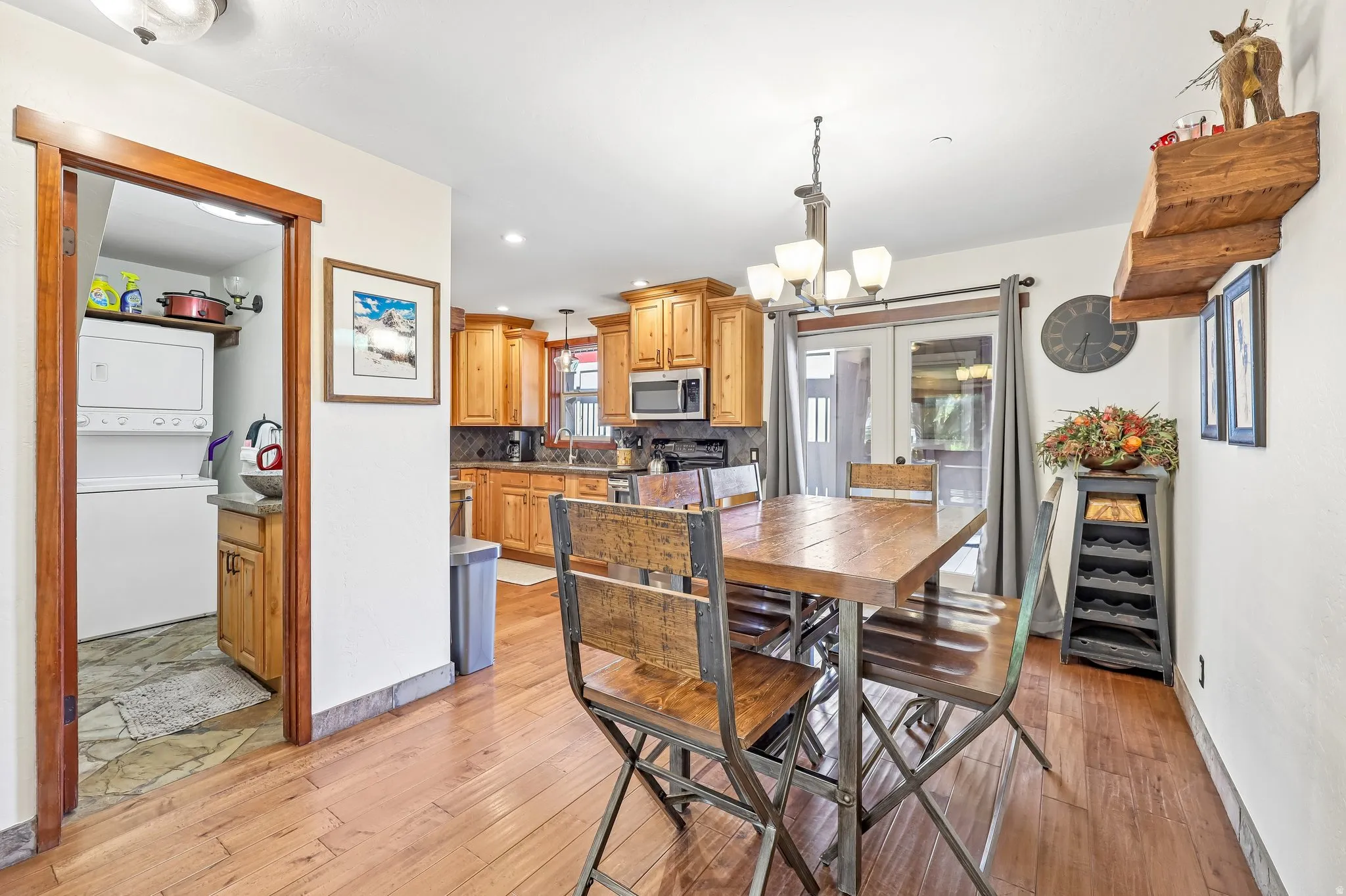 Open-concept dining area featuring wood-finish flooring, a built-in light fixture, and French doors