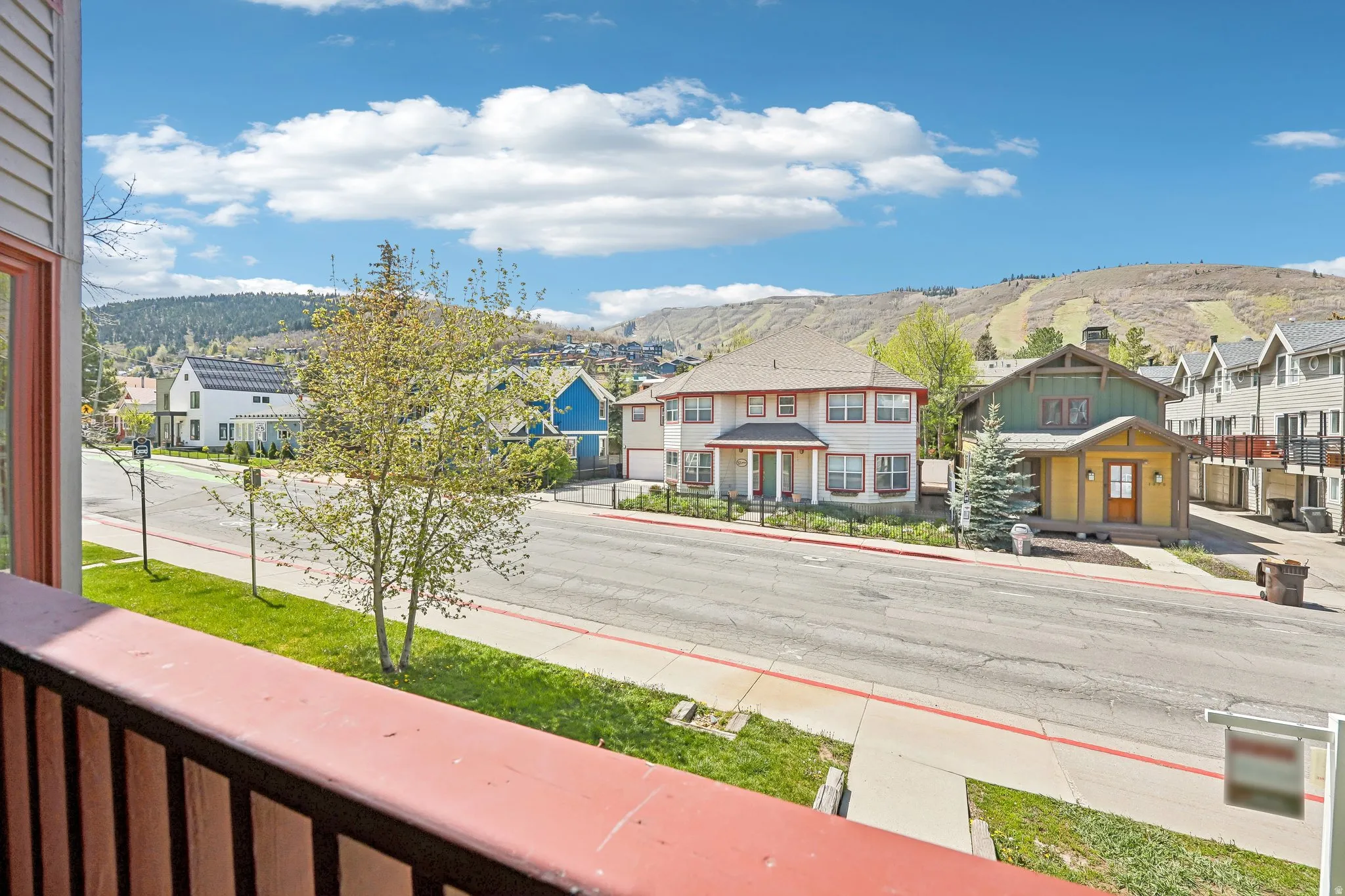 Balcony overlooking a street with mountain terrain in the background