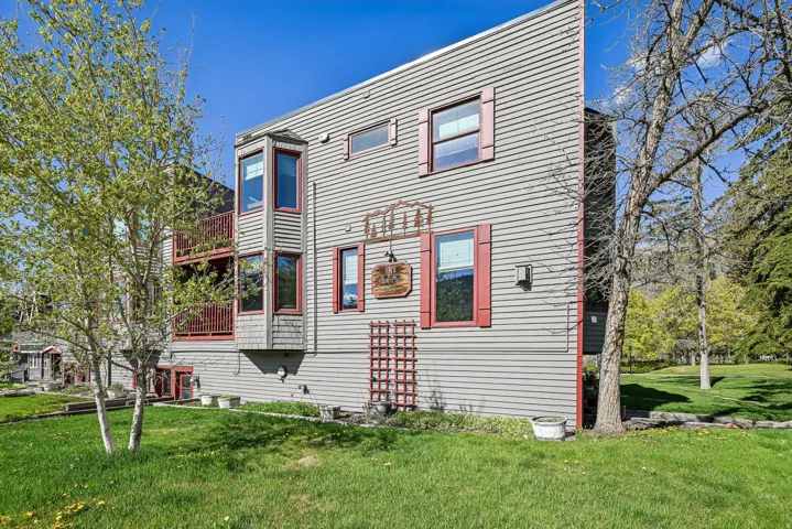 Multi-story exterior with horizontal siding and red window shutters